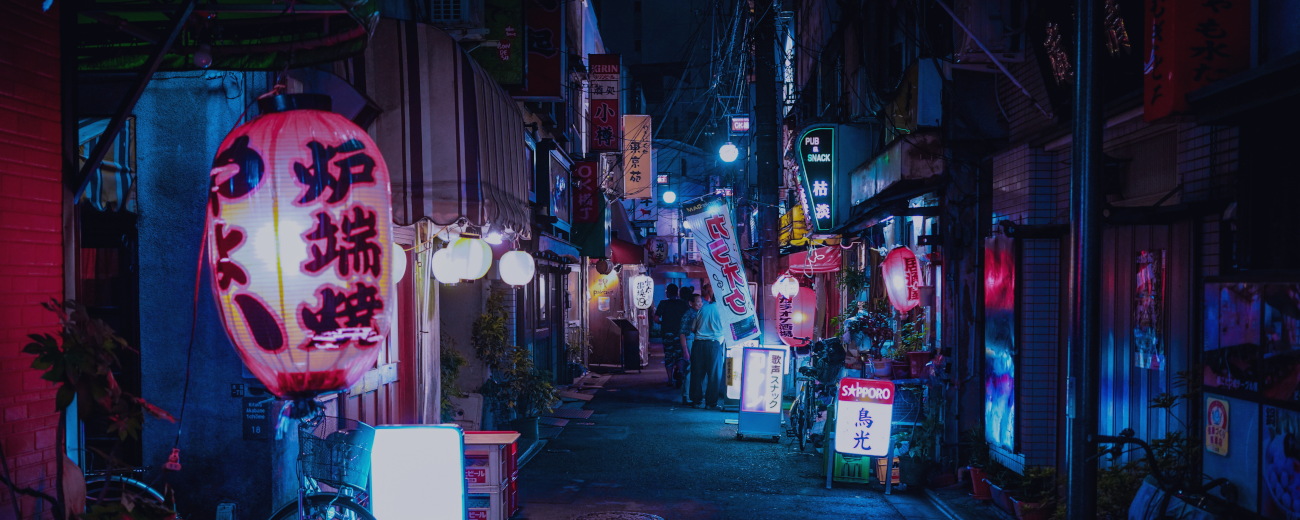 Narrow Tokyo side-street at night, with blue and purple hues from neon lighting